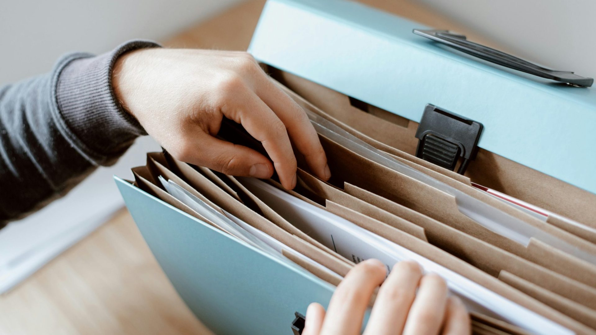 Une main explorant un dossier rempli de documents © 2020 Anete Lusina / Pexels